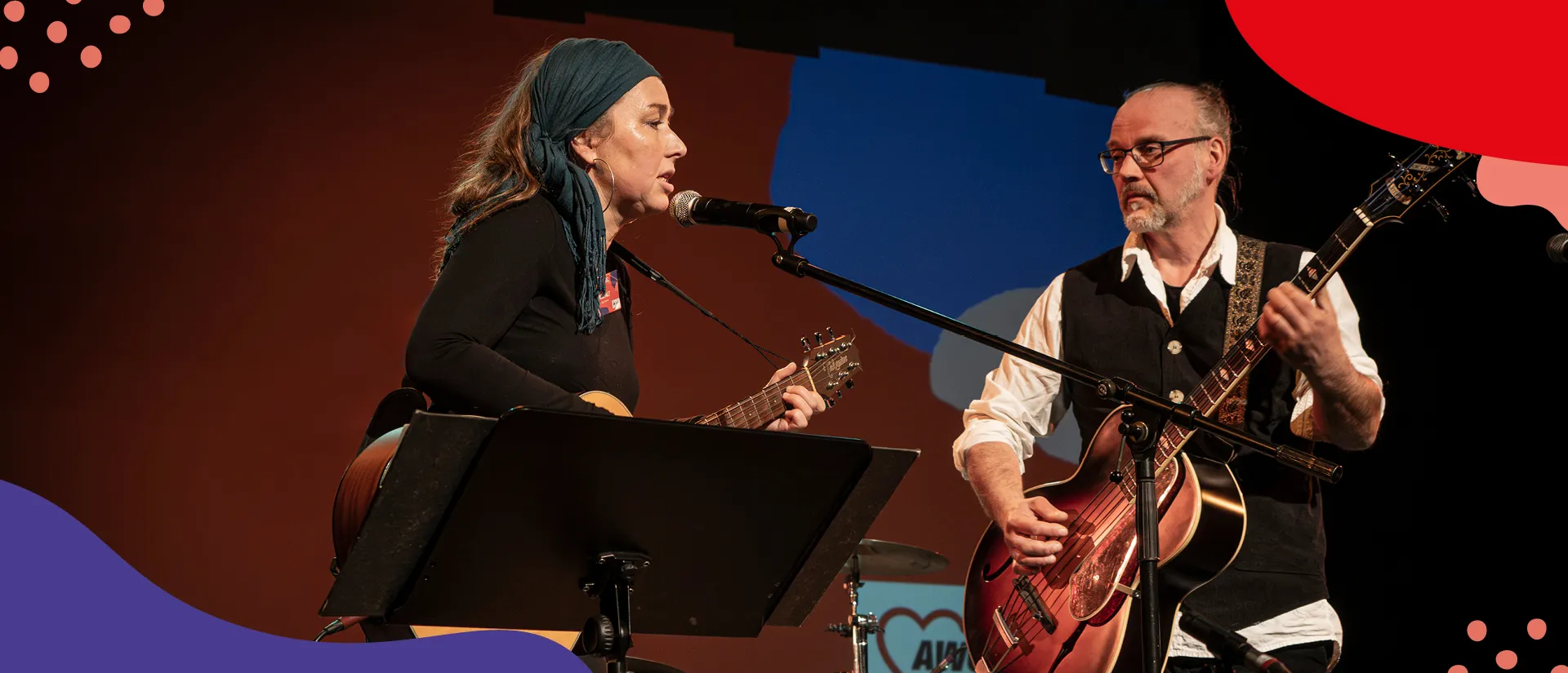 Eine Frau und ein Mann stehen auf der Bühne und spielen Gitarre und singen dabei | © Simone Hryzyk | AWO Bremerhaven